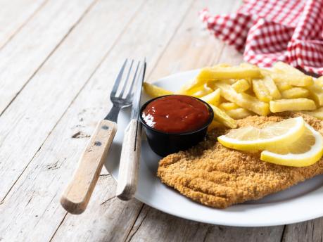 wiener-schnitzel-with-fried-potatoes-wooden-table